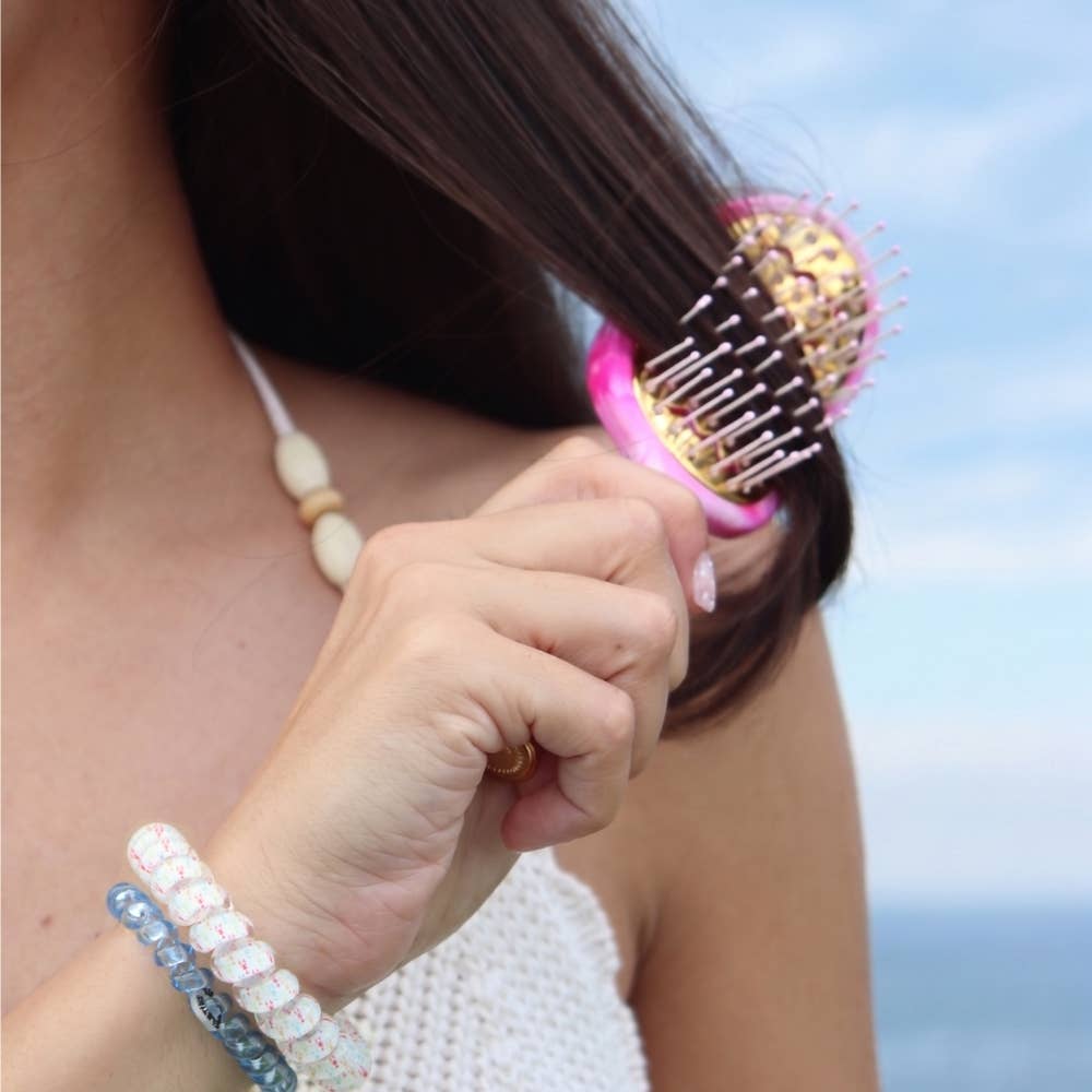 Mini Vented Brush by TELETIES with black plastic bristles and a compact, rounded handle for easy styling and detangling.