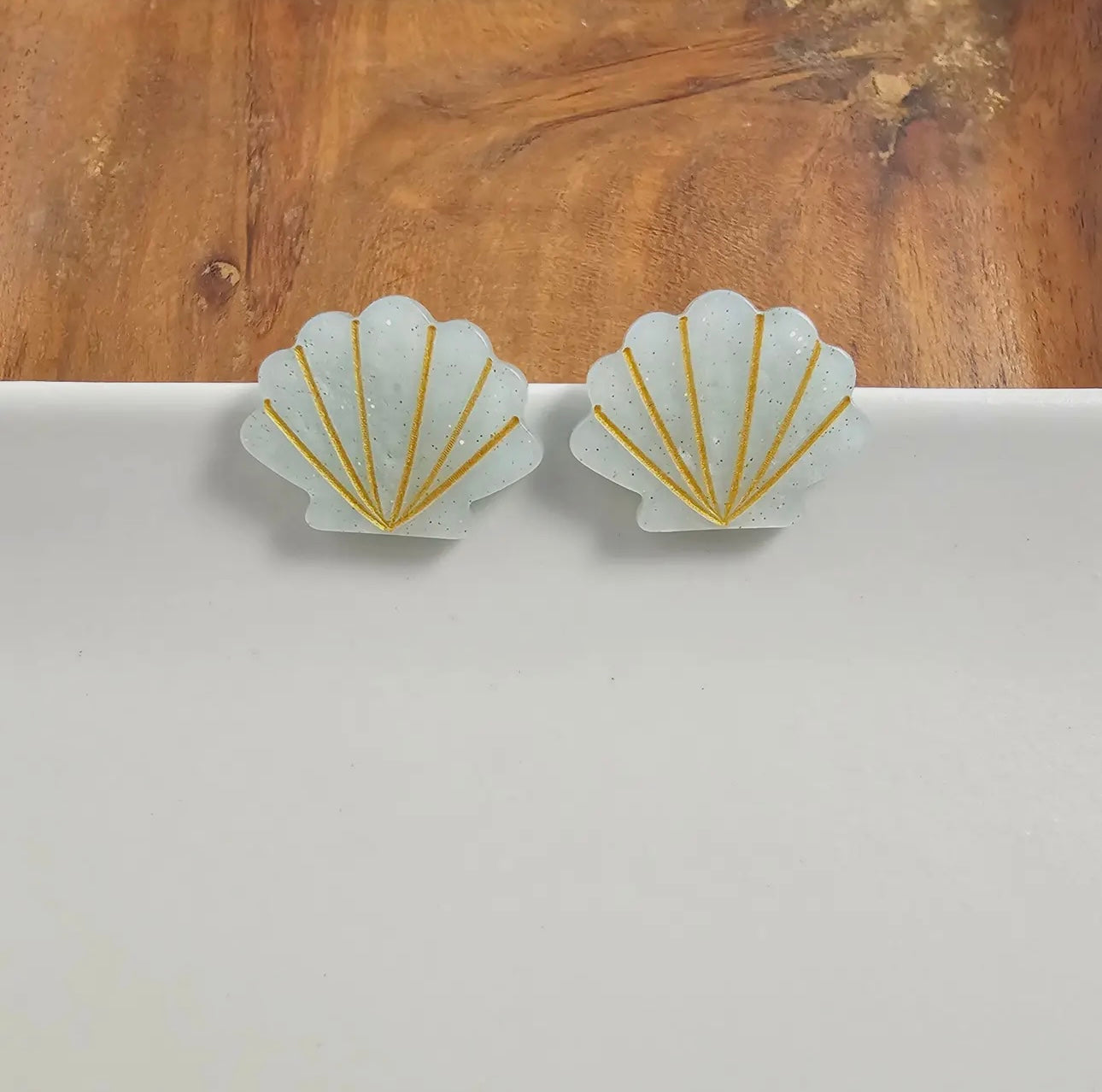 Spiffy & Splendid seashell stud earrings featuring small, natural shell charms with silver posts and butterfly backs.