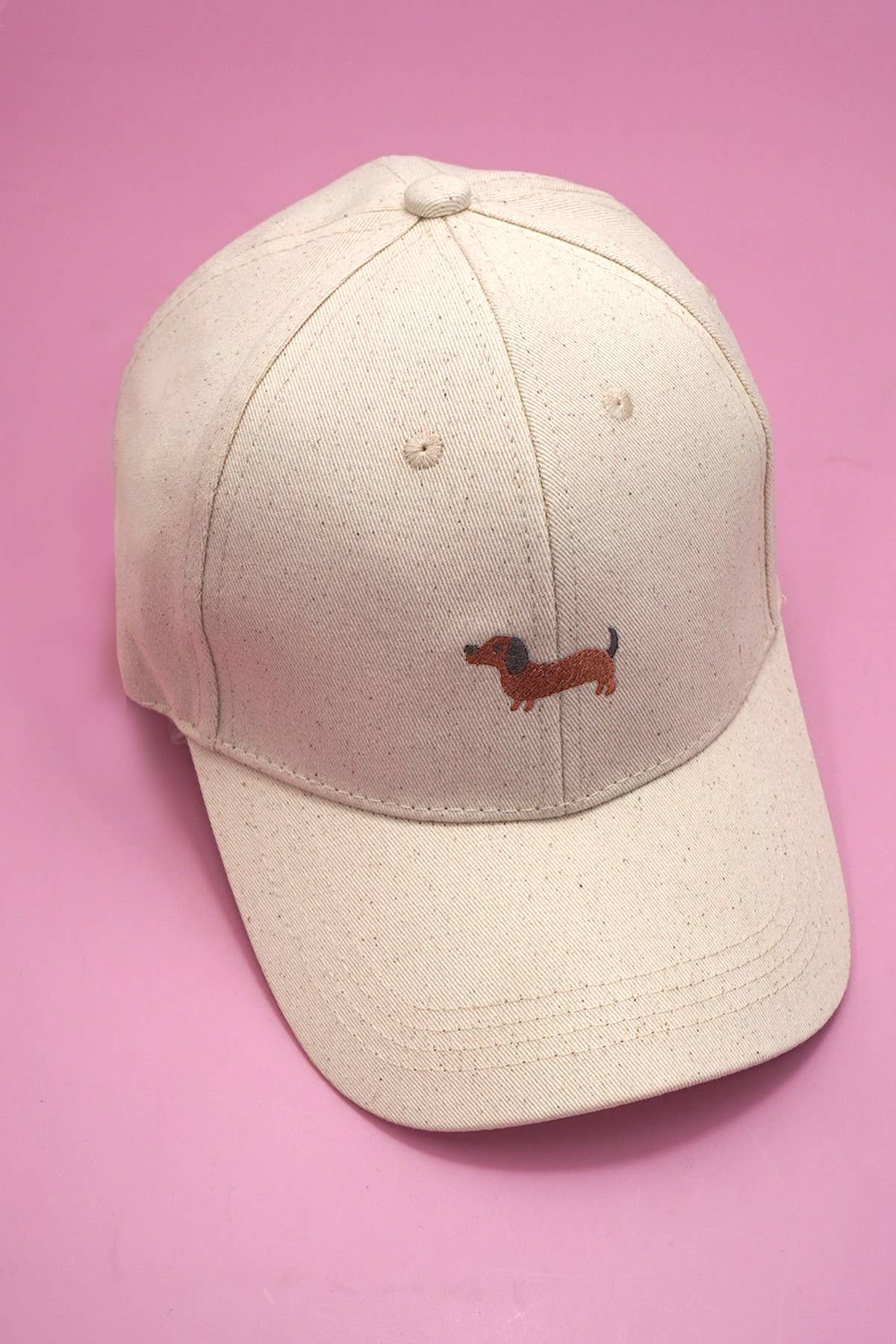 JOSSLYN wall to wall classic cap with dog embroidery, featuring a structured baseball style and adjustable strap, in neutral colors.